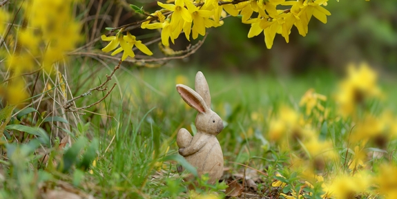 Hasenfigur aus Holz sitzt auf Wiese